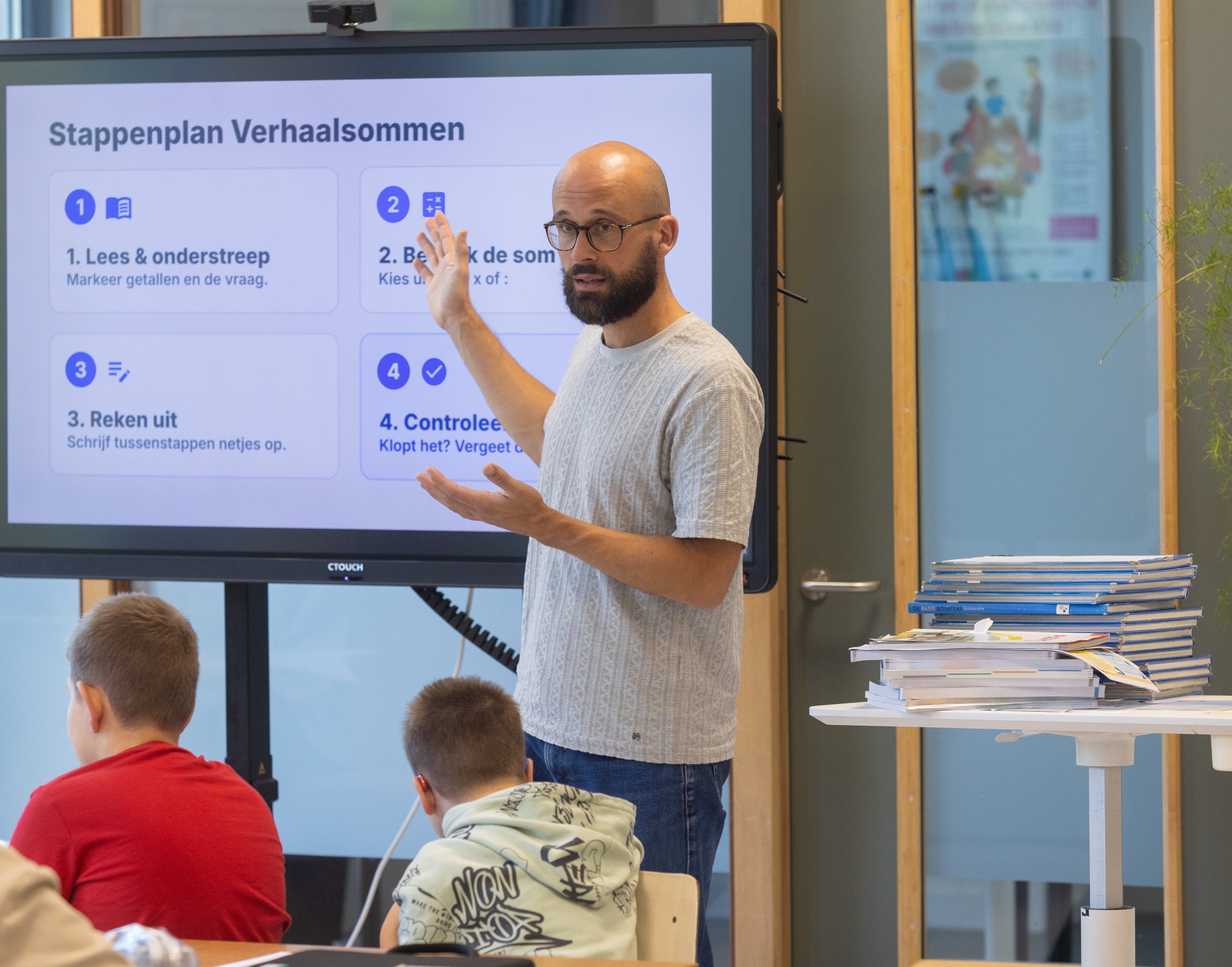 Docent legt bij het digibord een stappenplan uit aan leerlingen