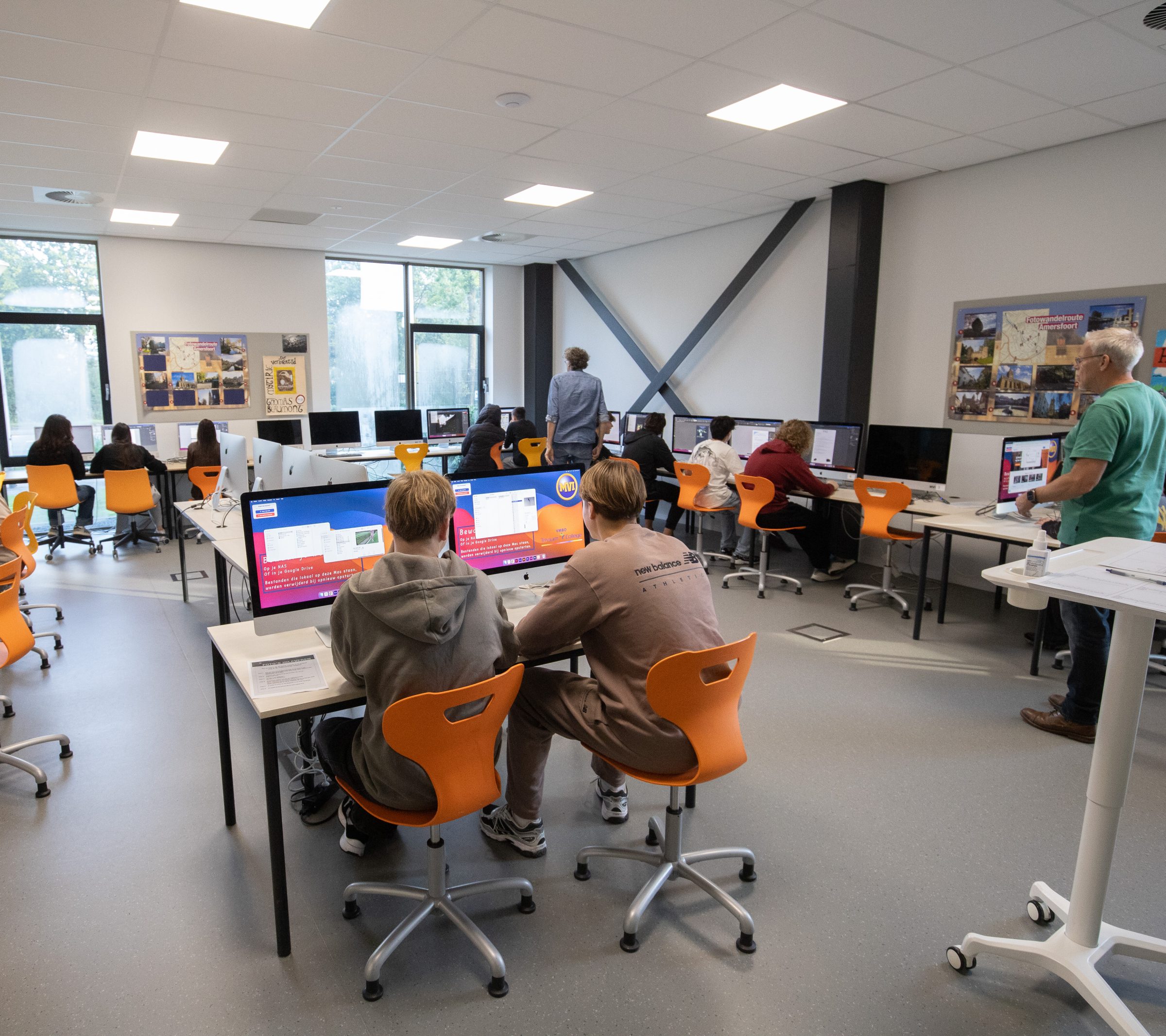 Leerlingen werken achter computers in het lokaal van Media, Vormgeving & ICT